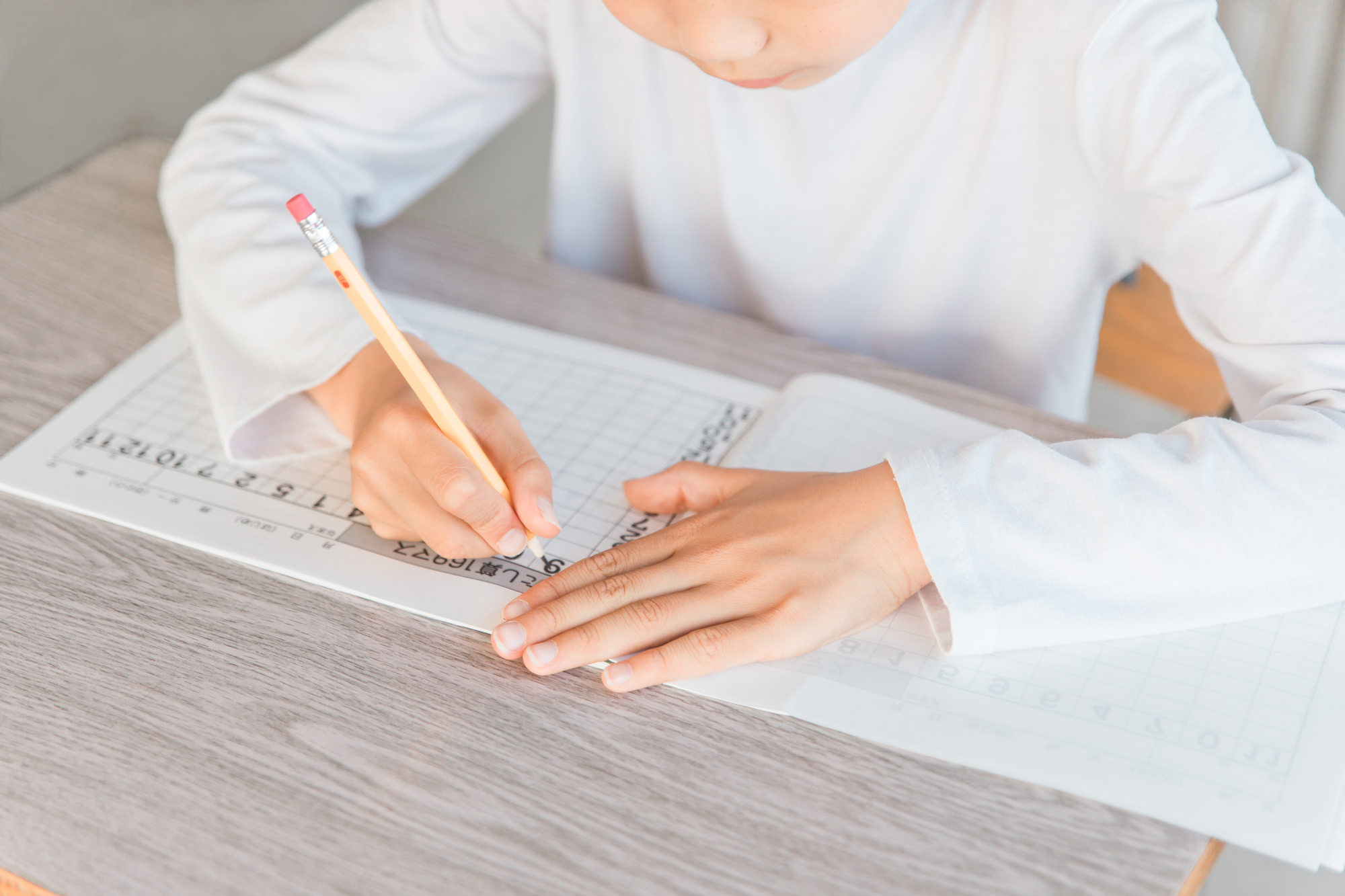 ノートに向かって集中して学習する手元